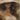 Close-up of a face beneath a hat brim, lips and wavy hair falling onto her chest. Brim of Secrets